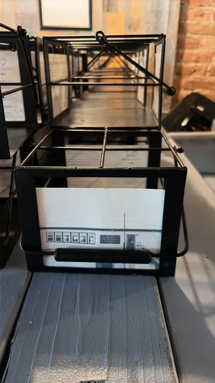 Table condiment caddies. Includes (53) units constructed of black wire and sheet metal. Features divided compartments, integrated card or menu display