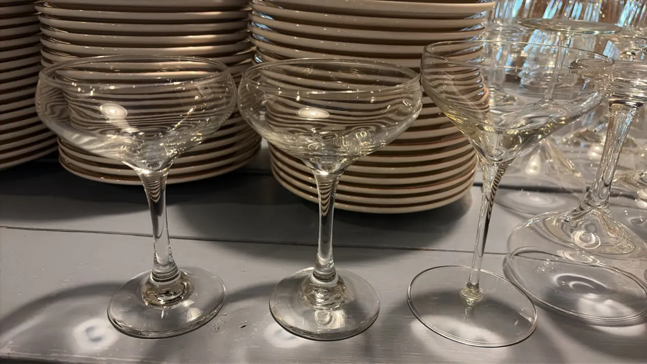 Martini glasses. Features clear glass coupe-style bowls with stemmed footed bases. Background dinnerware not included.