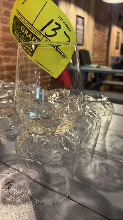 Set of (7) clear bar glasses. Features a faceted, textured exterior pattern. Background glassware not included.