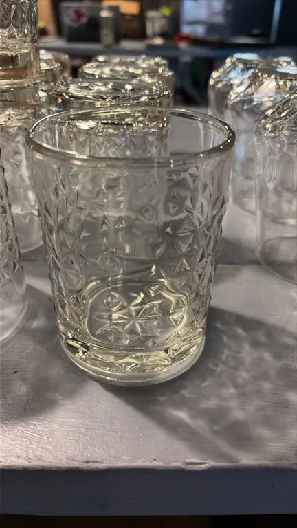Set of (15) clear glass water tumblers. Features a textured geometric diamond pattern.