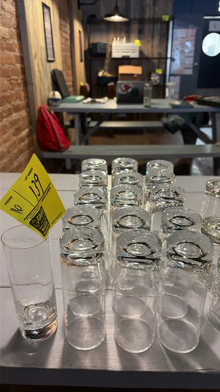 Lot of (16) clear glass highball glasses. Features straight cylindrical sides and a heavy sham base.