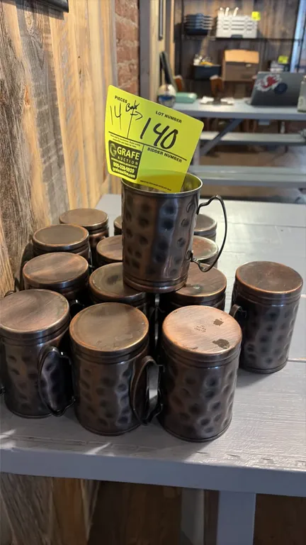 Lot of (14) brushed copper mugs. Features a hammered exterior finish, side handles, and metal interior lining.