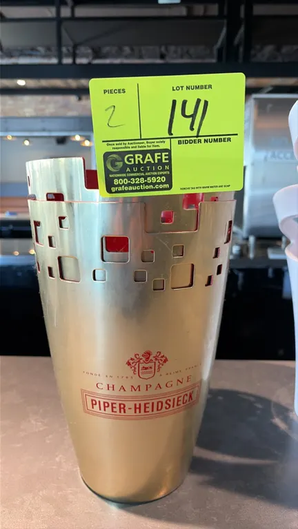 Piper-Heidsieck champagne buckets. Features gold-tone exterior with geometric cutout pattern, red interior lining, and branded Champagne Piper-Heidsie