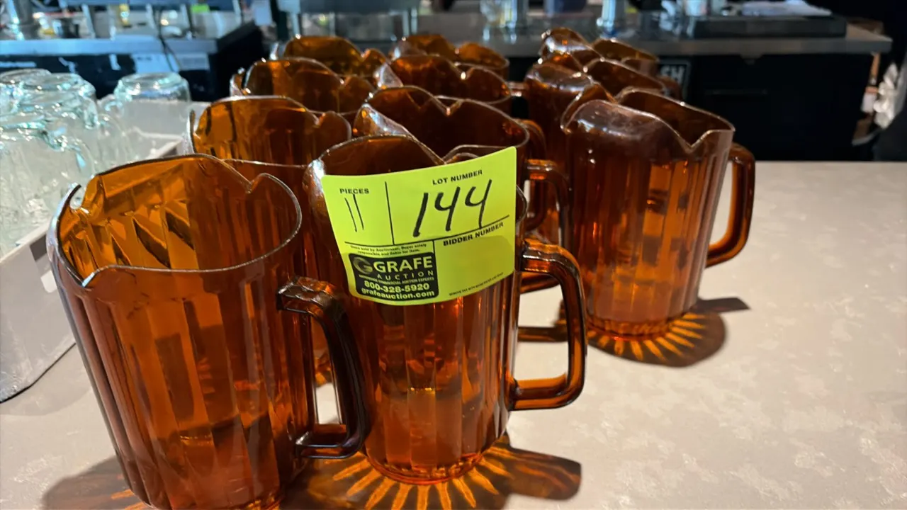 Plastic beverage pitchers. Features amber-tinted construction, paneled sides, integrated pour spouts with ice catchers, and side handles.