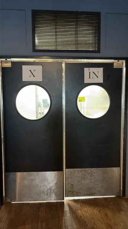 Double swinging restaurant traffic doors. Features circular vision panels, lower metal kick plates, hinges, and frame. 35 1/2" x 82 1/2".