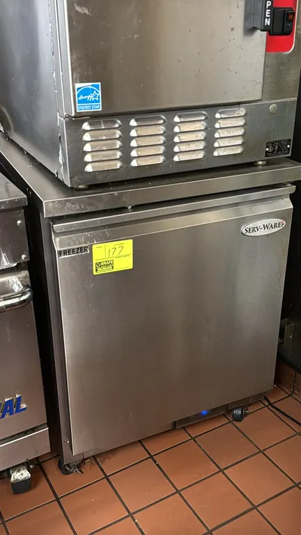 Serv-Ware UCF-27-HC self-contained undercounter reach-in freezer. Features stainless steel exterior, single solid door, wire shelf, and digital temper