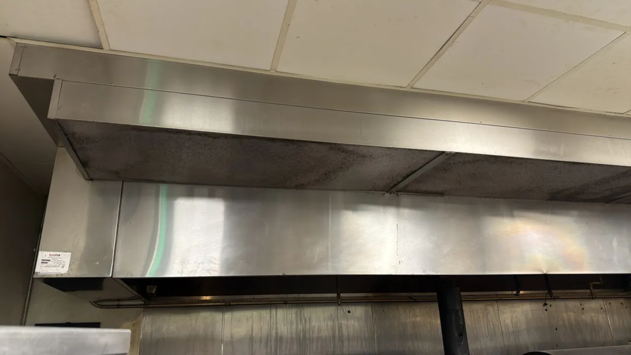 Captive Air stainless steel exhaust hoods. Features integrated fire suppression system piping and nozzles, stainless steel baffle grease filters, and