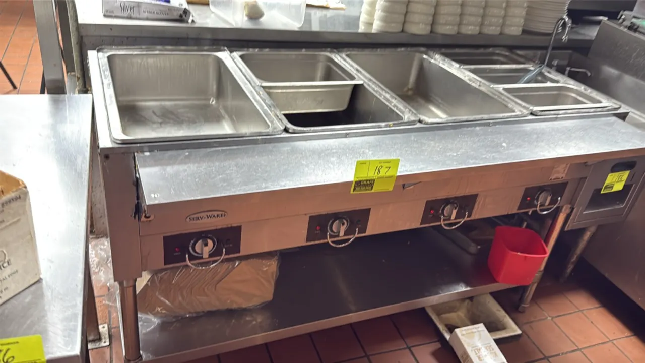Serv-Ware electric 4-well hot food table. Features stainless steel construction, 4 independently controlled wells, front stainless steel shelf, and un