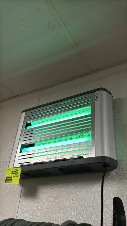 Halo Synergetic commercial insect light trap. Features dual UV lamps, front access louvered panel, and internal glueboard. 22"W. Wall-mounted.