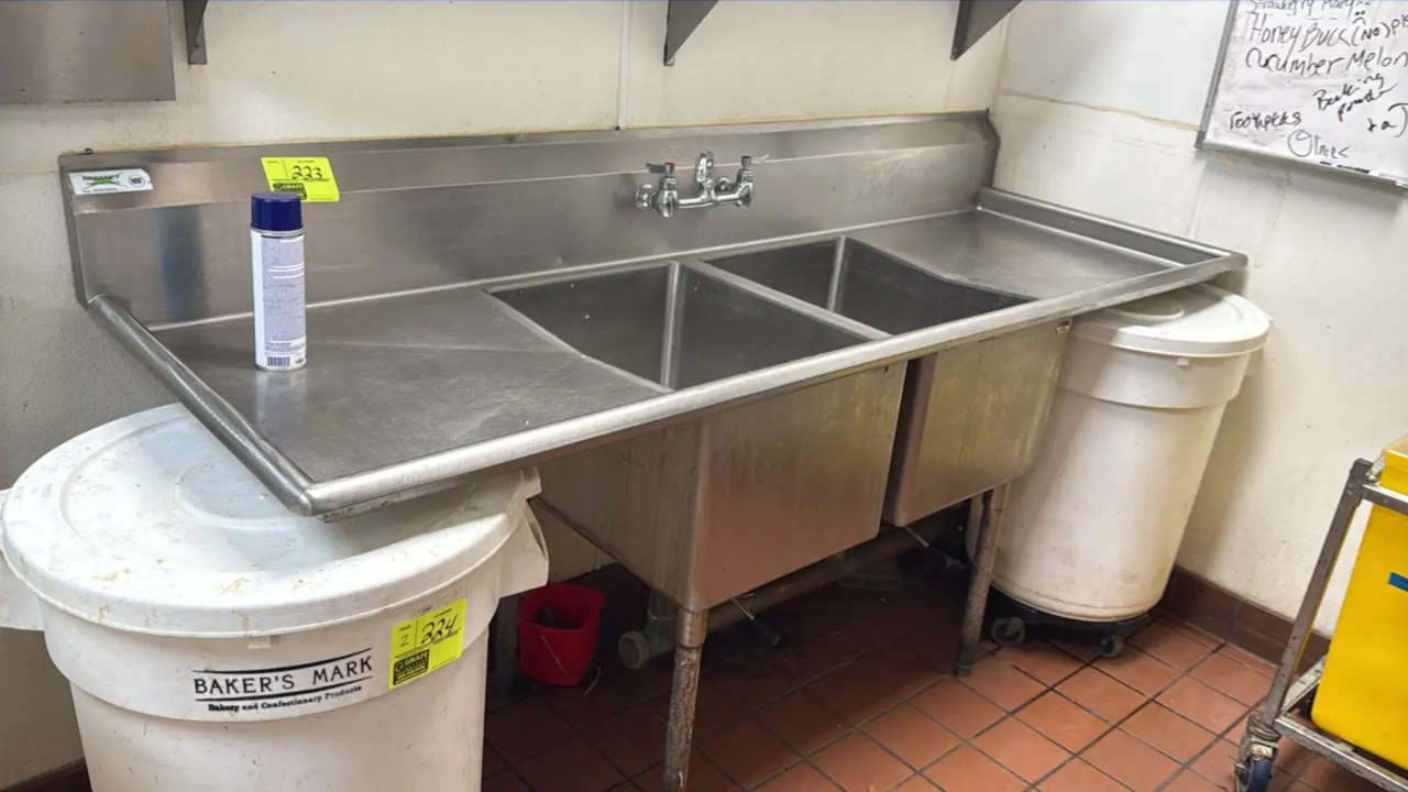Stainless steel 2-compartment sink. Features left and right drainboards, integrated backsplash, splash-mount faucet, and lever waste drains. Dimension