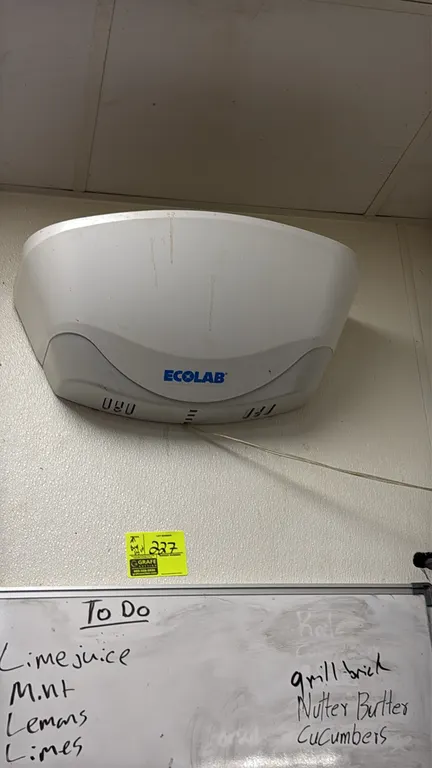 Ecolab insect light trap. Features a molded white plastic housing. Wall-mounted design with power cord.
