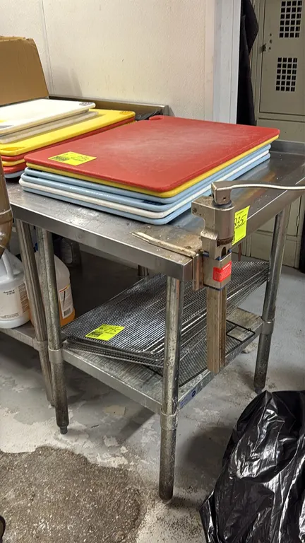 Stainless steel work table with backsplash and undershelf, equipped with a table-mounted Edlund manual can opener. Tubular legs with adjustable bullet