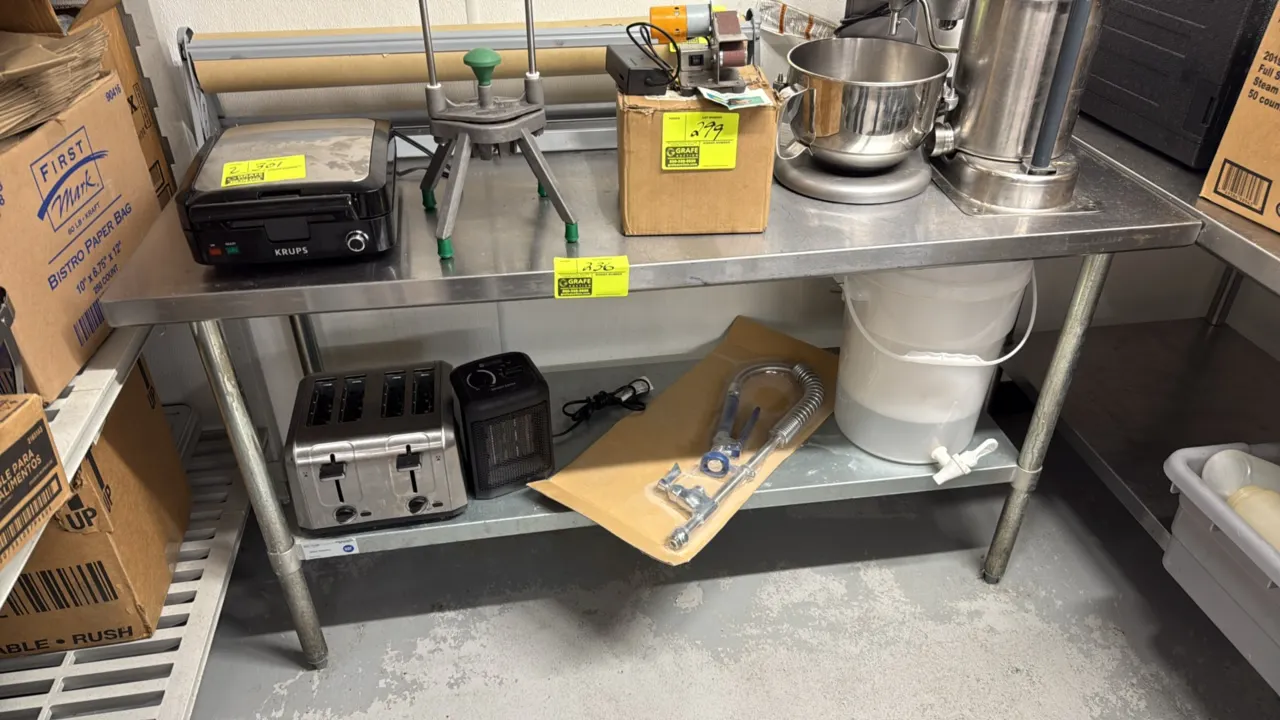 Stainless steel work table with undershelf. Features tubular legs with adjustable bullet feet. 60" x 24". Contents not included.
