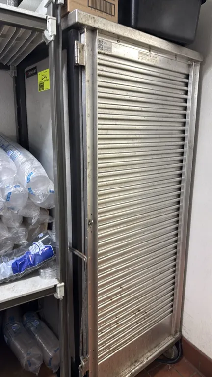 Cres Cor hot food electric transport cabinet. Features aluminum construction and a roll-up tambour door. Mounted on casters. Items on top and surround