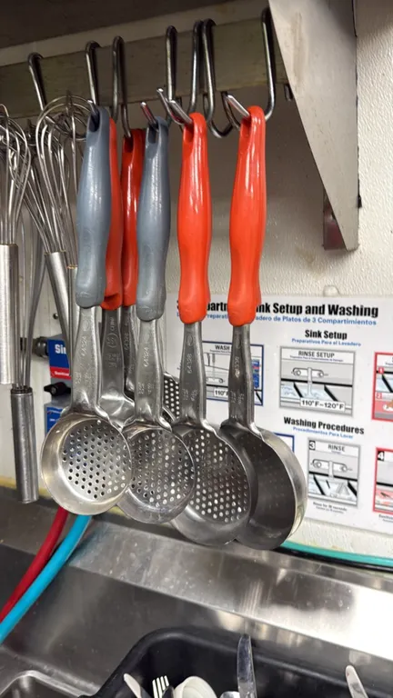 Vollrath stainless steel portion ladles. Features color-coded plastic handles, perforated and solid bowls, and assorted capacities including 4 oz. and