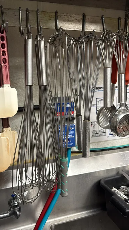 Assorted stainless steel wire whisks. Features a variety of lengths and styles, including balloon and French whisks with tubular stainless steel handl