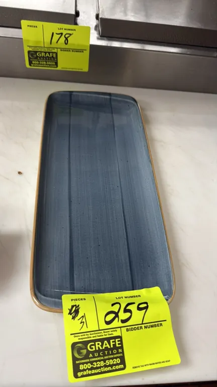 Bonna porcelain rectangular plates. Includes (31) plates featuring a blue glazed finish with tan rim accents. Dimensions: 13" x 6".