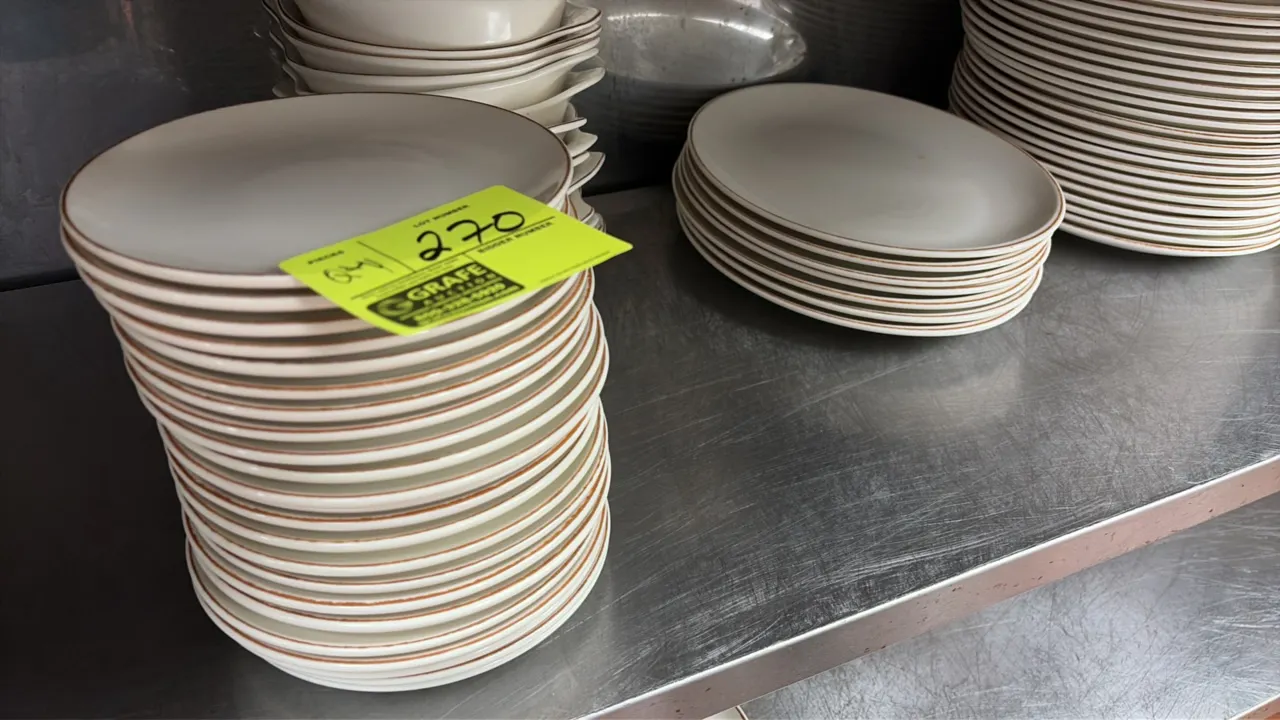 Assorted restaurant china dinnerware. Includes round plates, oval platters, rectangular dishes, and small handled bowls. Ceramic construction with bro