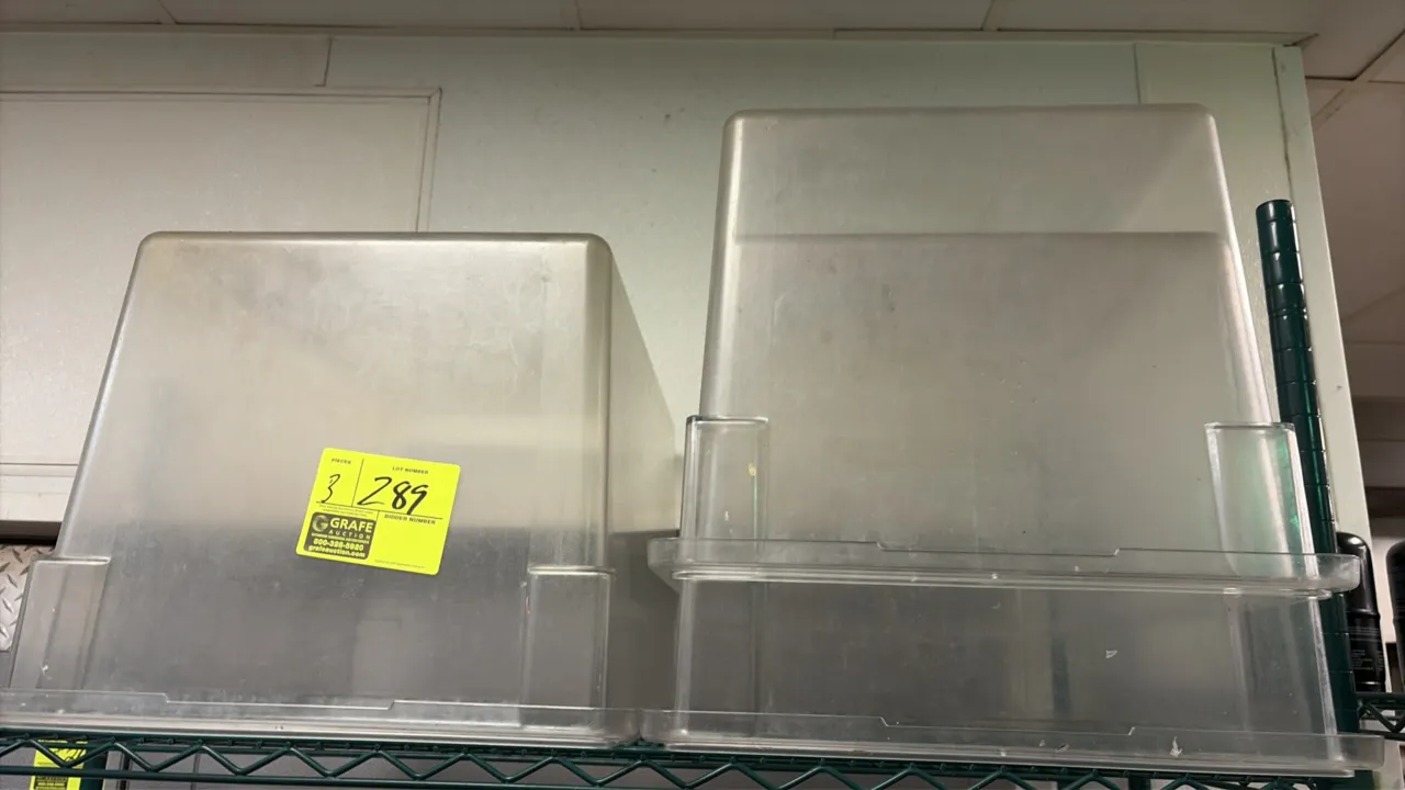 Cambro clear plastic food storage pans. Clear polycarbonate construction with molded handles and stacking lugs. Wire shelving and background items not
