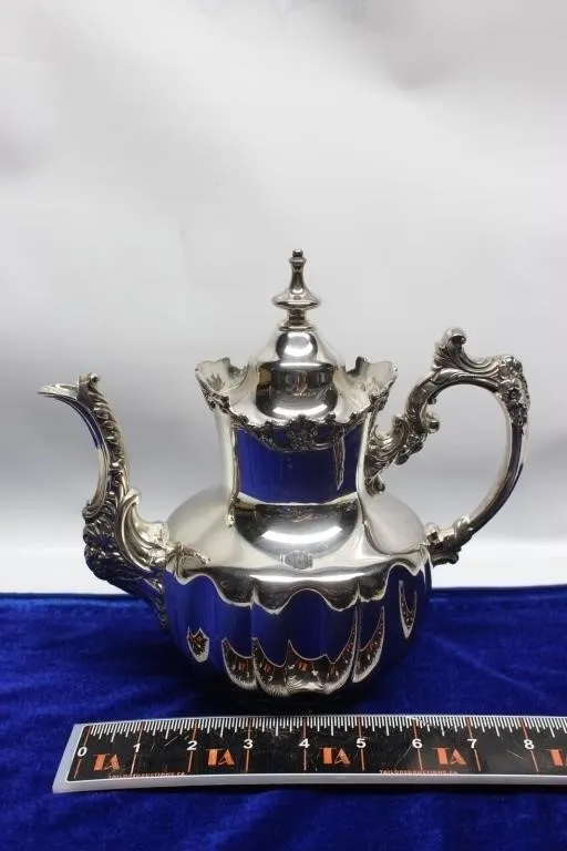 Silver-plate teapot with ornate handle and finial