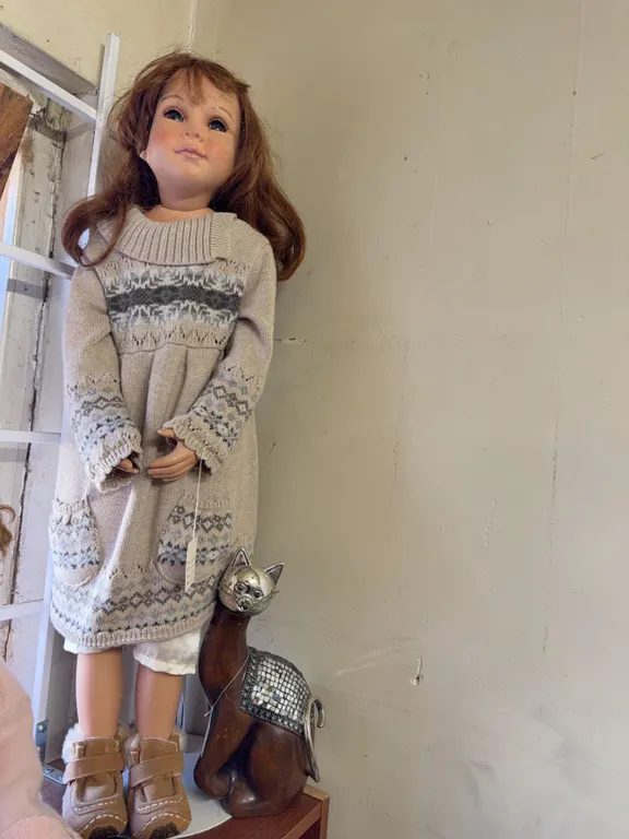 Large Porcelain Doll With Brown Hair Wearing Sweater Dress And Brown Boots