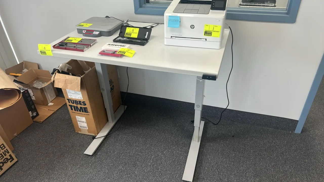 ESI electric adjustable height standing desk. Features a white laminate top, push-button up/down controller, and telescoping legs. 48" x 30". Mounted