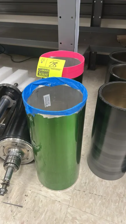 Printing press blanket cylinders. Features green exterior finish and hollow core design. Includes (2) cylinder sleeves. Surrounding items not included