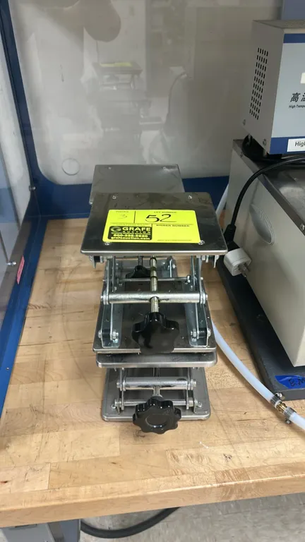 Stainless steel laboratory scissor jacks. Features manual screw adjustment knobs and scissor lift mechanisms. Circulator bath and background equipment