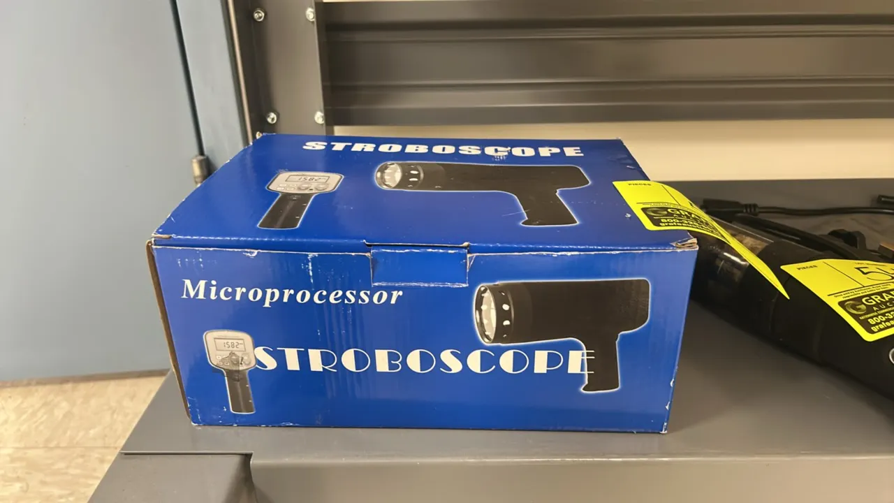 Microprocessor digital stroboscope. Features handheld pistol-grip design, digital display, and included power cord. Housed in original fitted foam pac
