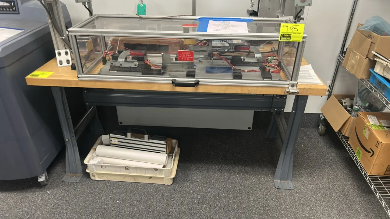 Industrial table. Features a solid wood top mounted on a painted metal base with cross support. 60" x 30". Note: Machine assembly on tabletop and cont