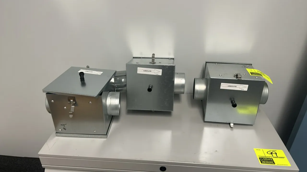 Galvanized metal HVAC duct filter boxes. Features round duct collar connections, removable access covers with tension latches and pull knobs, and dire