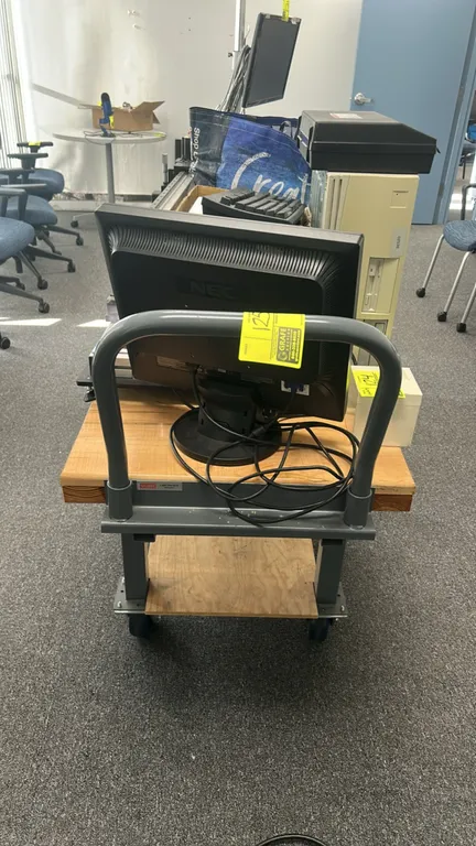 Uline 2-tier utility cart. Features a solid wood top, lower wood shelf, tubular steel push handle, and painted steel frame. 4'L. Mounted on casters. N