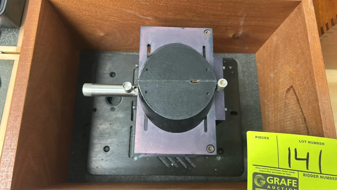 Thermo Spectra-Tech 4X beam condenser. Features optical condenser assembly mounted to an adjustable base plate. Includes fitted wooden storage case.