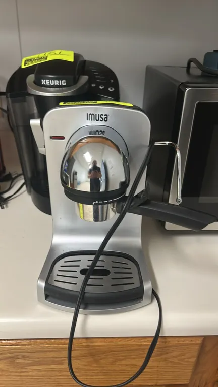 IMUSA Bistro 4-cup electric espresso and cappuccino maker. Features steam frothing wand, portafilter, and removable drip tray with grate. Note: Carafe
