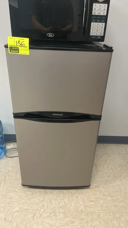 Frigidaire 2-door compact refrigerator and freezer combo. Features stainless-look finish with black cabinet, top freezer compartment with wire shelf,