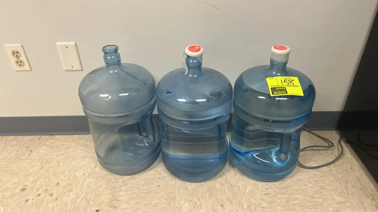 Crystal Rock 5-gallon plastic water jugs. Lot includes (3) jugs featuring integrated molded carry handles. Two jugs are capped and one is uncapped.
