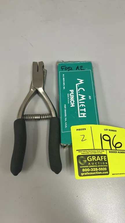 M.C. Mieth handheld hole punch. Features spring-action return, cushioned foam handle grips, and solid metal construction. Includes original box.