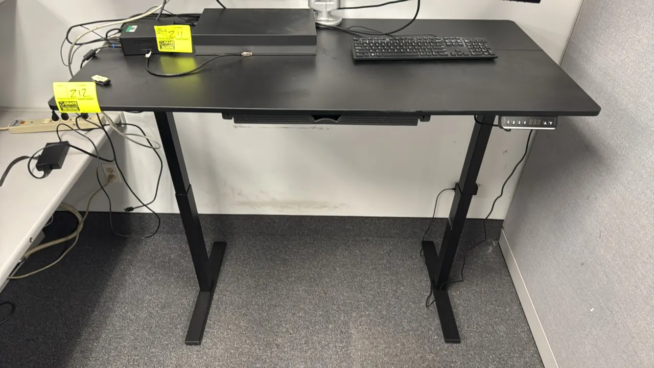 2023 SHW electric sit/stand desk. Features a black top, motorized height adjustment with digital memory preset controller, pull-out storage drawer, an