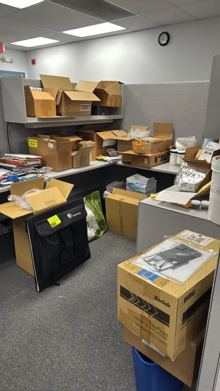 Package lot of remaining items in cubicle. Includes LimoStudio portable photo case, Kodak NexPress imaging supplies packaging, bottles of toner or pow
