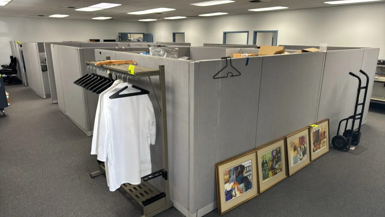 Fabric panel cubicle workspace system. Features (8) 10' x 8' stations with gray fabric acoustic panels, attached laminate work surfaces, overhead shel