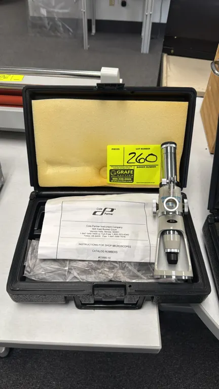 Cole-Parmer 03890-30 60x shop microscope. Features 60x magnification, dual focusing knobs, illuminator bracket, and open base design. Includes fitted