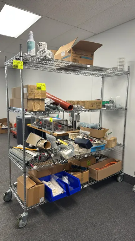 Chrome 4-tier portable wire shelving rack. Features (4) adjustable wire shelves. 72" x 24" x 78". Mounted on (4) swivel casters with brakes. Contents