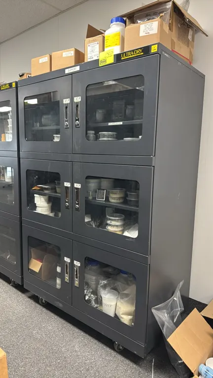 Manncorp Ultra-Dry 3-compartment metal storage cabinet. Features (6) windowed doors with latching handles, interior shelving, and ESD-safe design. 48"