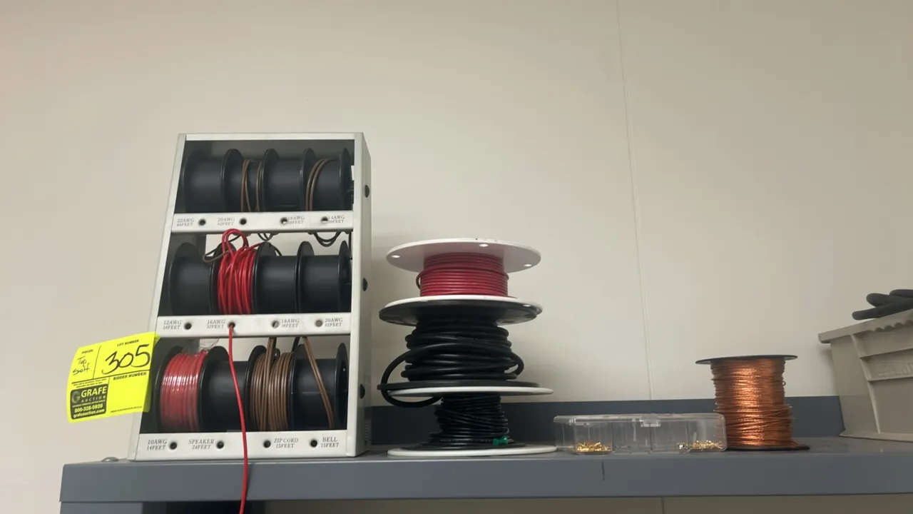 Assorted electrical and workbench supplies lot. Includes wire spools with benchtop spool dispenser rack, loose wire and cable spools, electronic contr