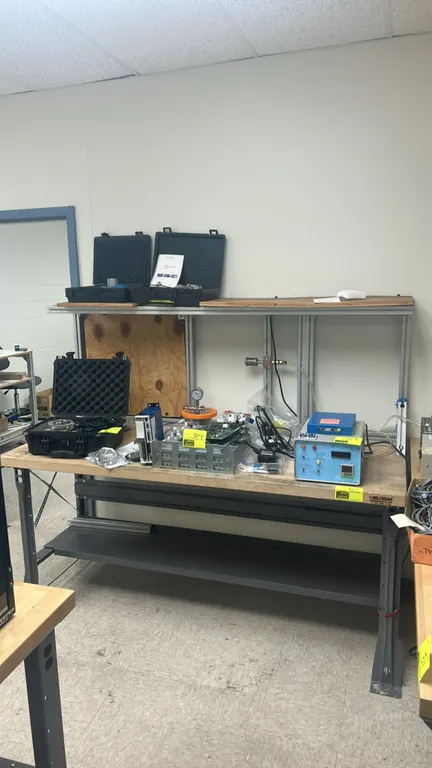 Global Industrial workbench. Features a wood top, upper shelf with aluminum framing, steel lower shelf, and steel legs. 72" x 30". Contents not includ