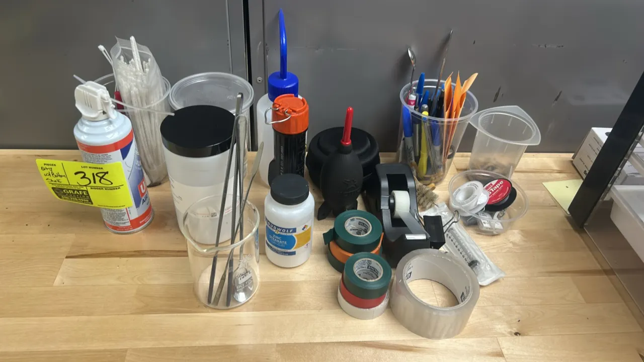 Assorted laboratory materials, poly organizer baskets, and shelf contents. Includes plastic organizer baskets, glass beaker, laboratory tweezers and s