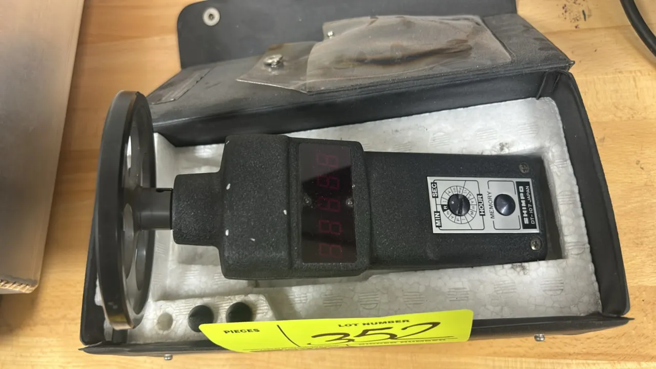 Shimpo DT-107 contact digital tachometer. Includes surface speed wheel attachment, two contact adapters, and fitted storage case. Features digital dis