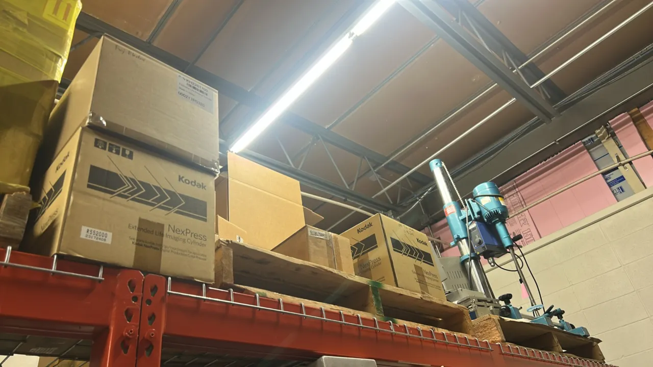 Package lot including Kodak NexPress Extended Life imaging cylinders in boxes, an industrial pillar drill press, and remaining contents on pallets. Dr