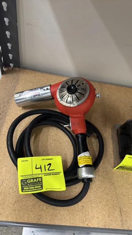 Master Appliance HG-501 heat gun. Features red cast housing, adjustable air intake, chrome nozzle, and contoured handle with attached power cord. Elec