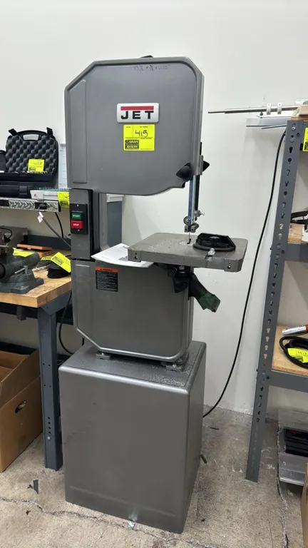 Jet J-8201K 14" metal and wood vertical bandsaw. Features a tilting table, miter gauge, and enclosed cabinet stand. Stock: 414500. S/N: 18120765. Moto